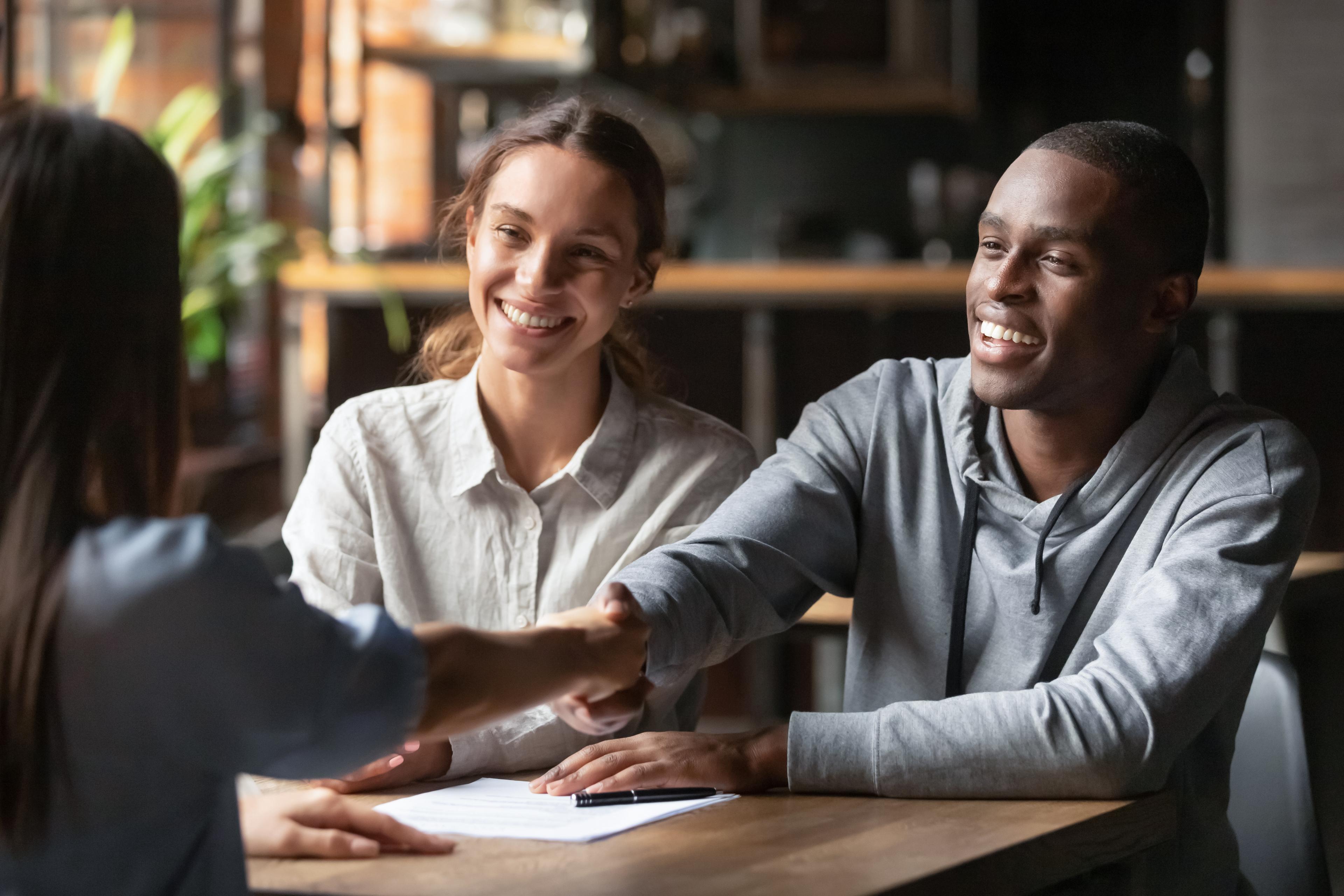 Happy couple signing paperwork with a tax professional